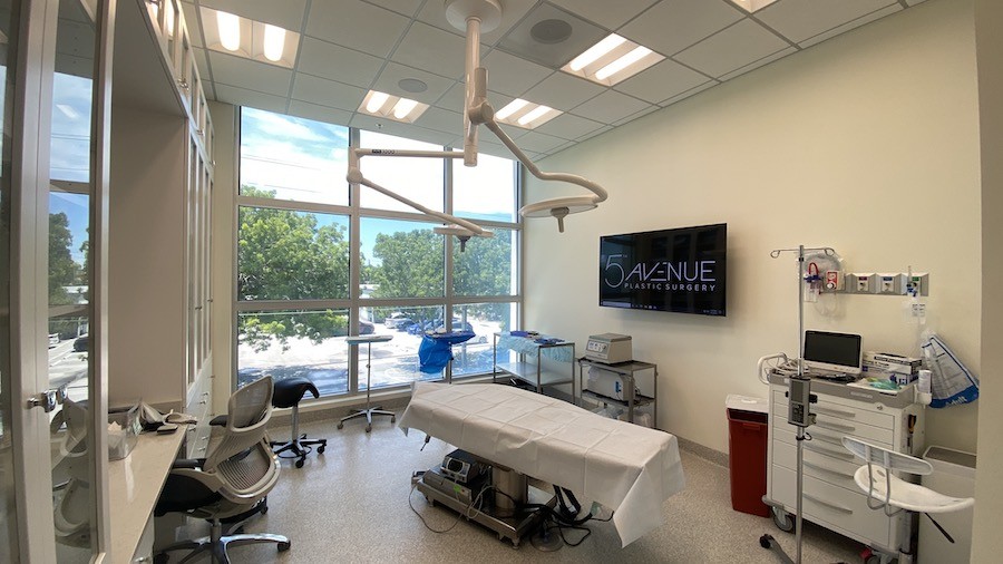 A plastic surgery operating room with commercial AV including a large display and in-wall speakers.