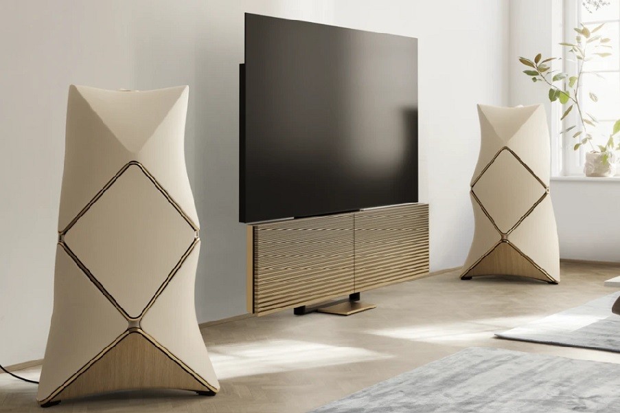 Bang & Olufsen cream-colored Beolab 90 floorstanding speakers with a TV in between. 