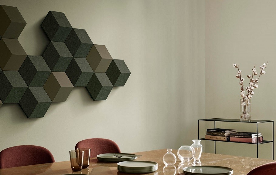 A large, geometric Bang & Olufsen sound system on the wall of a dining room. 
