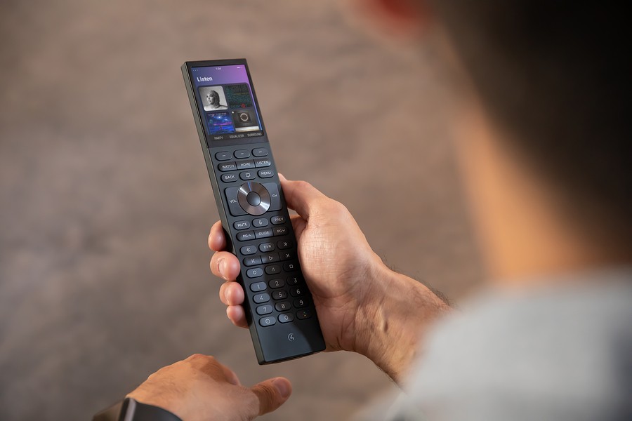 Hand holding the Control4 Halo remote with a touch screen and hard buttons.