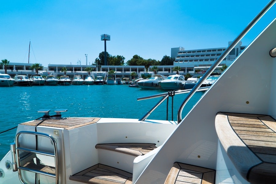  Wooden steps on a luxury yacht that’s situated in a marina. 