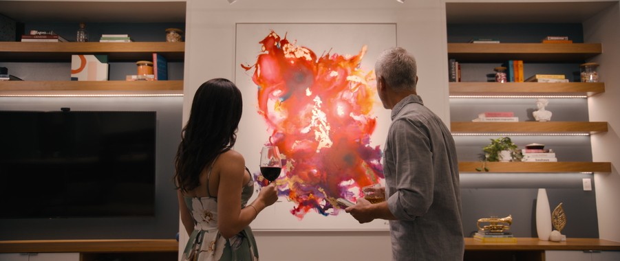Two people looking at modern artwork on the wall illuminated by lighting design. 